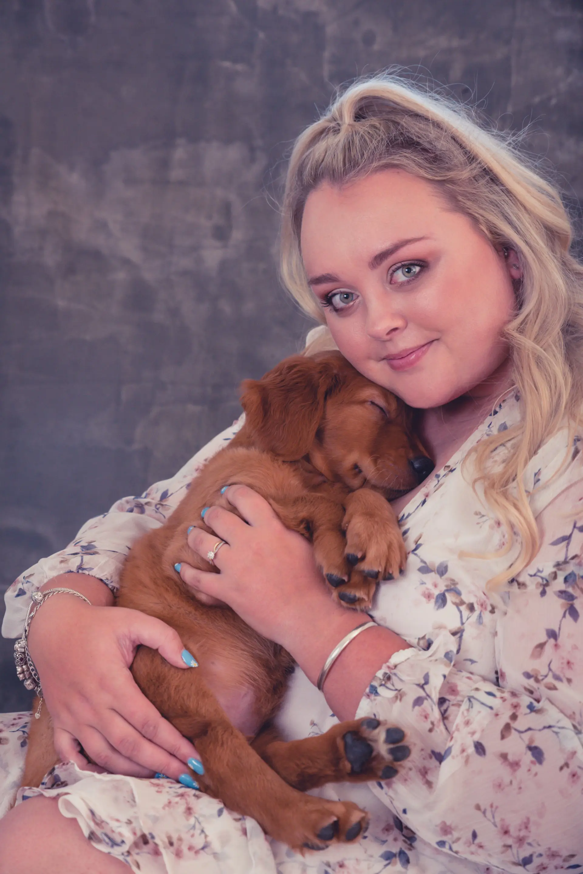 Trainer Madeleine de Vrije cuddling a sleepy red puppy